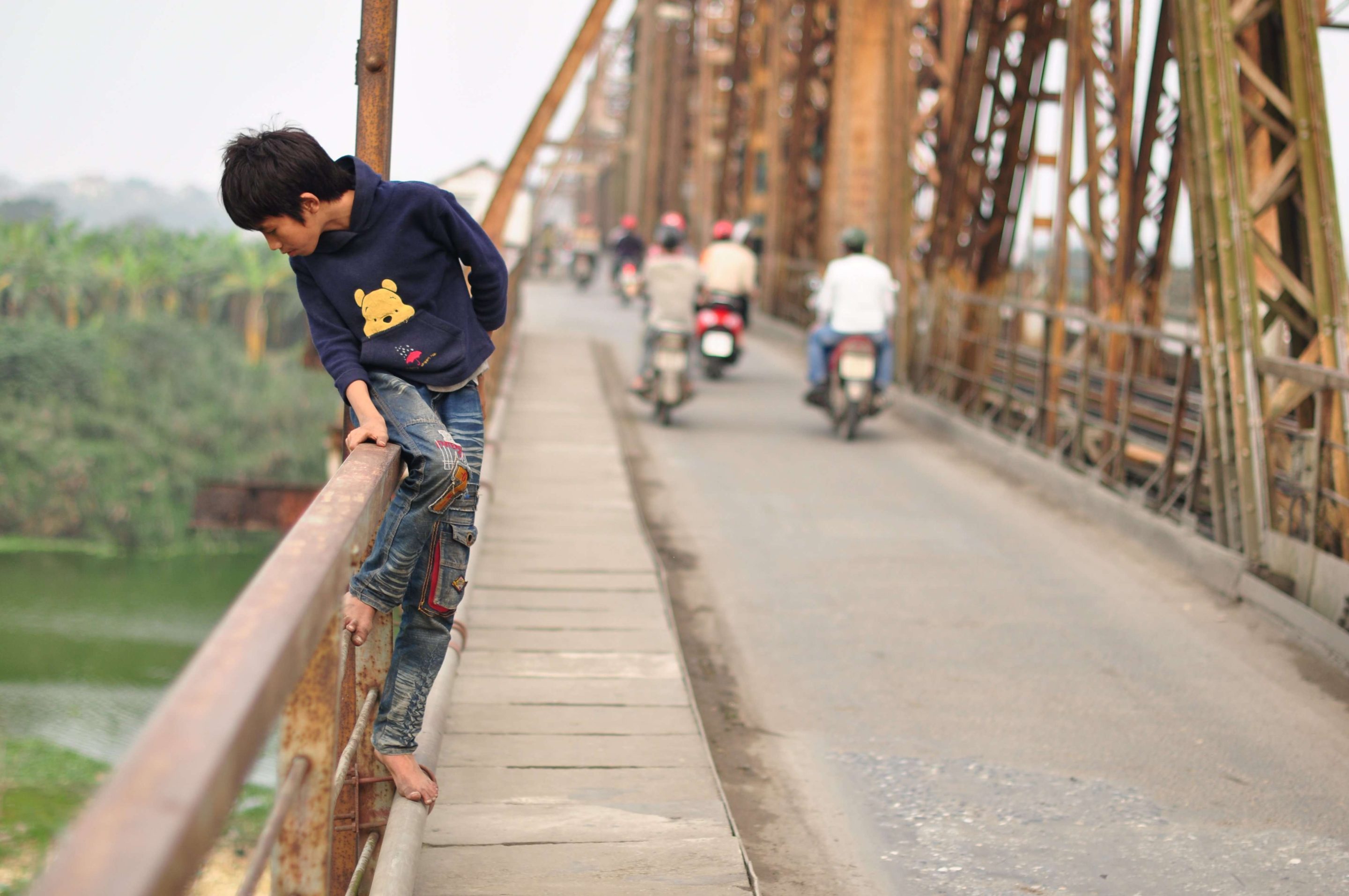 Young boy in Vietnam looking over a bridge where those vulnerable to human trafficking sleep